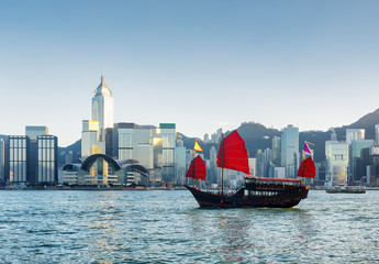 Naklejka premium Traditional Chinese sailing ship in Victoria harbor at evening