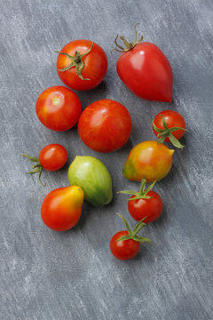 Variety of tomato fruits over painted textile background