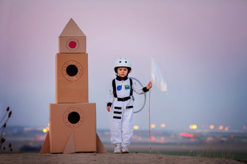 Adorable little boy, dressed as astronaut, playing in the park w