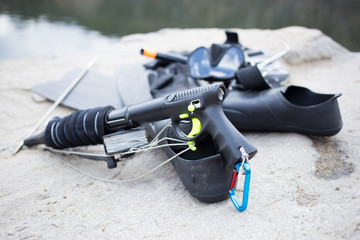 Equipment for underwater hunting near the pond on the rock. 