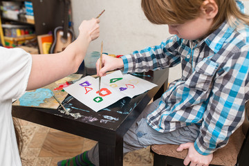 Fototapeta premium mother with boys son paint colors at home