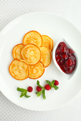 sweet pancakes with cherry sauce decorated with mint and raspberries