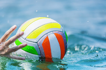 Hand of swimmer reaches water beachball