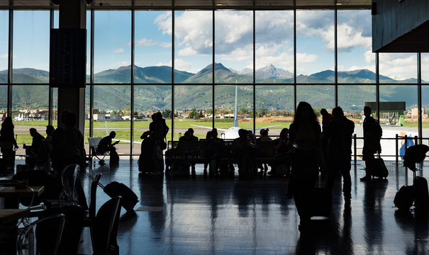 Silhouette crowd people waiting for aiplane in terminal with mountain background, Milano Bergamo airport