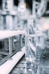 Robotic factory line for processing and bottling of pure spring water into canisters and bottles. Selective focus. Short depth of field.