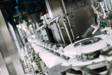 Robotic factory line for processing and bottling of pure spring water into canisters and bottles. Selective focus. Short depth of field.