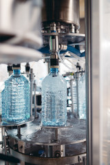 Robotic factory line for processing and bottling of pure spring water into canisters and bottles. Selective focus. Short depth of field.