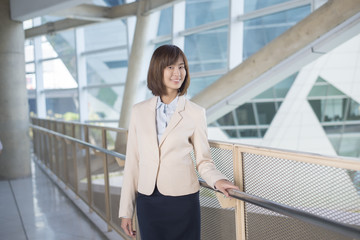 Attractive asian business woman smiling outside office