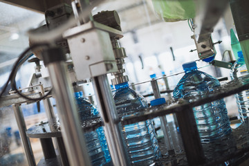 Robotic factory line for processing and bottling of pure spring water into canisters and bottles. Selective focus.