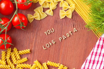 Cooking with love. Different kinds of pasta on wooden background.