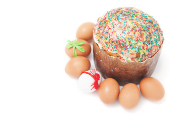 Easter eggs lie around cake on white background