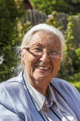 senior woman sitting in her garden