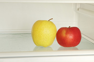 Red and yellow apple in domestic refrigerator taken closeup.Toned image.