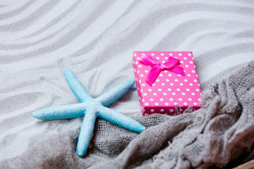starfish, gift and fishnet on the sand