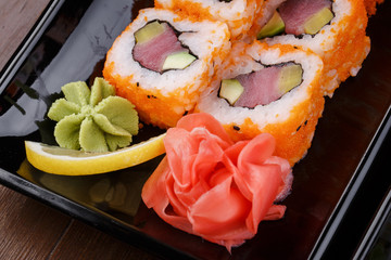 Japnes food. Sushi roll with tuna and radish, on black backgorun