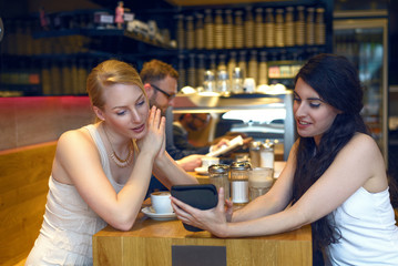 Zwei junge Frauen lesen auf einem digitalen Tablet