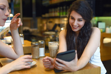 Zwei junge Frauen lesen auf einem digitalen Tablet