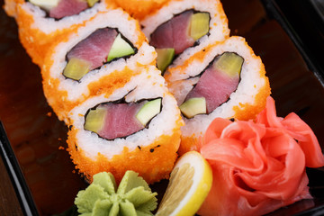 Japnes food. Sushi roll with tuna and radish, on black backgorun