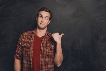 Portrait of handsome young man pointing on the chalkboard