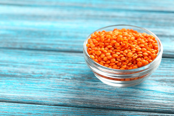 Red lentils in bowl on a blue wooden table
