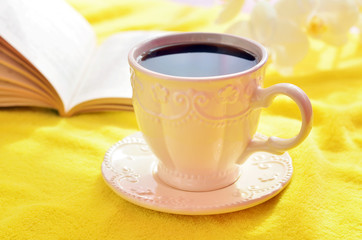 cup of coffee on a yellow blanket