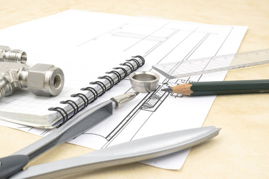 Drawings, components and design tools on the table of an engineer or designer illustrating research and development process in engineering and science. 