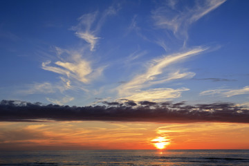Fototapeta na wymiar Threatening clouds over the festive sunset line.