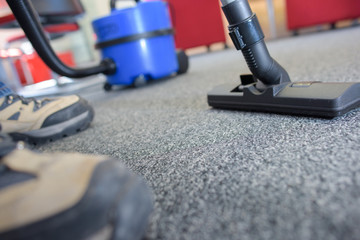 Fototapeta premium Closeup of male feet and vacuum cleaner