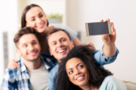 Positive delighted friends making selfies 