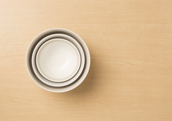 Three sizes empty bowls on wood background, top view