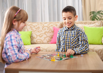 children playing board game ludo at home on the table