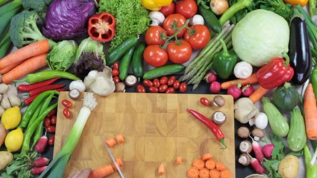 Fresh vegetables and chopping carrot on chopping board 