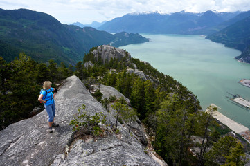 Woman Enjoying View from Mountain Top. 
Stawamus Shief Provincial Park, British Columbia, Canada. 