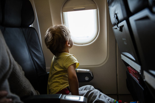 Boy looking out of window in airplane