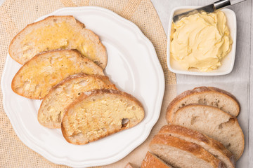 Naklejka premium Fresh bread and homemade butter on wooden background