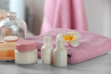 Fototapeta na wymiar Blue towel with cosmetics and soap on bathroom table