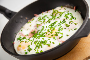 fried eggs with onions in a frying pan, selective focus