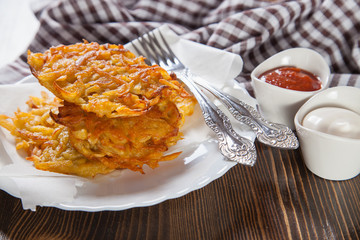 grated potatoes cutlets in a plate on a table, selective focus