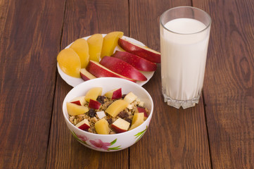 muesli with peach, apple and a glass of milk