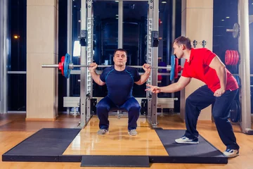  sport, fitness, teamwork, bodybuilding people concept - man and personal trainer with barbell flexing muscles in gym © satyrenko