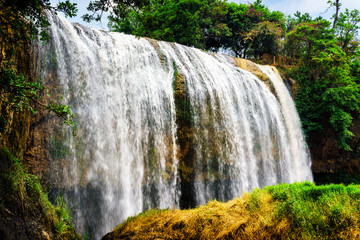 Obrazy na Plexi  Malowniczy wodospad z krystalicznie czystą wodą wśród zielonych lasów