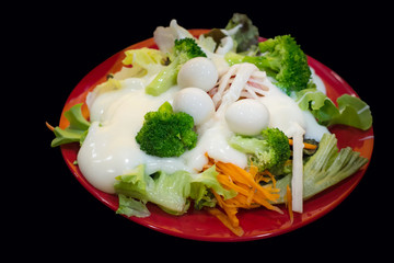 Cream salad with quail eggs, cherry tomatoes in red plate on tab