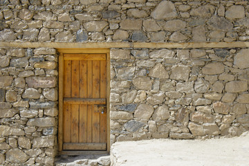Old wooden door on stone wall