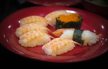 Sushi on red plate.