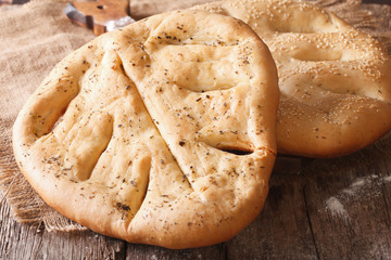 Homemade Fugasse French bread with sesame seeds and herbs closeup 
