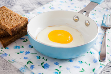 fried eggs in a frying pan on a table, selective focus