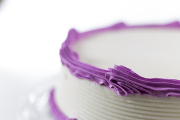 Cake with plain frosting and space for text on a bright backgrou