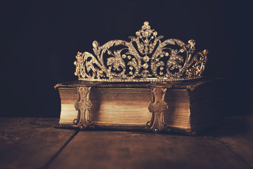 low key image crown on old book. sepia vintage filtered. selecti © tomertu