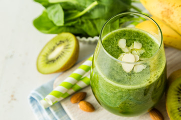 Green smoothie and ingredients on white background