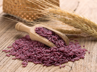 Purple rice on wooden background
